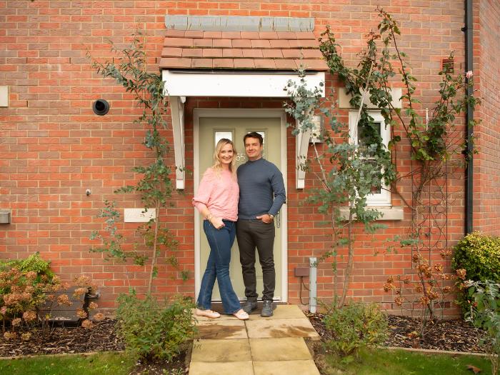 Ewa and Aleks pose for a photo at their front door