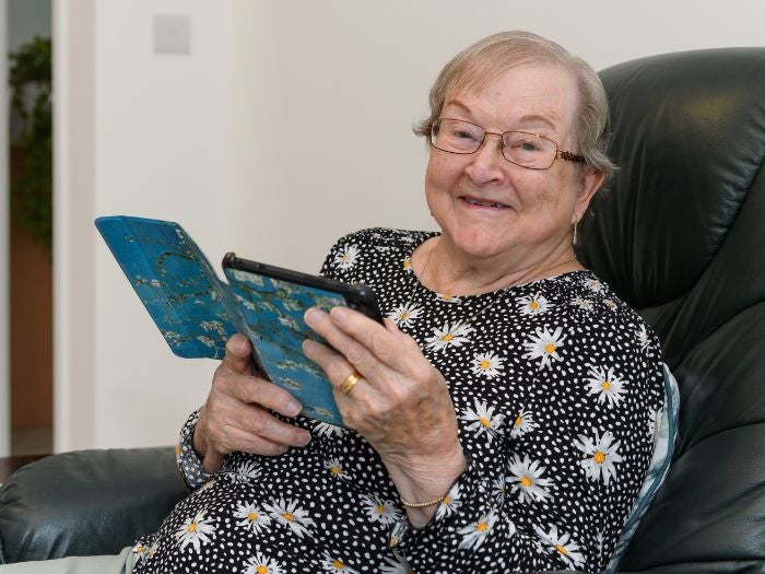 Heather relaxes in a leather armchair whilst using her tablet device