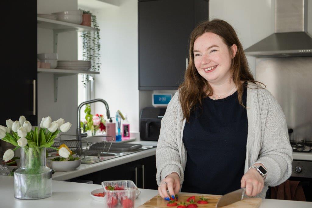 Paige cutting strawberries at the island in her kitchen