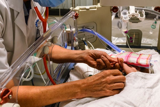 Baby op de Neonatale Intensive Care wordt onderzocht met een stesthoscoop door een neonatoloog