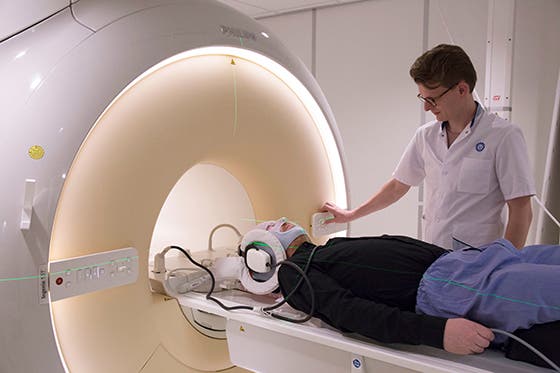 MRI technicus assisteert een patiënt die in een MRI-scanner ligt voor een onderzoek