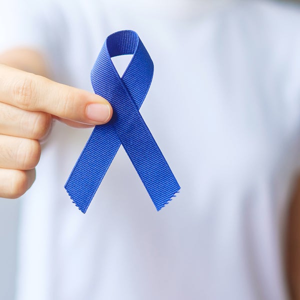 Een persoon met een blauw lint, dat symbool staat voor de strijd tegen darmkanker.