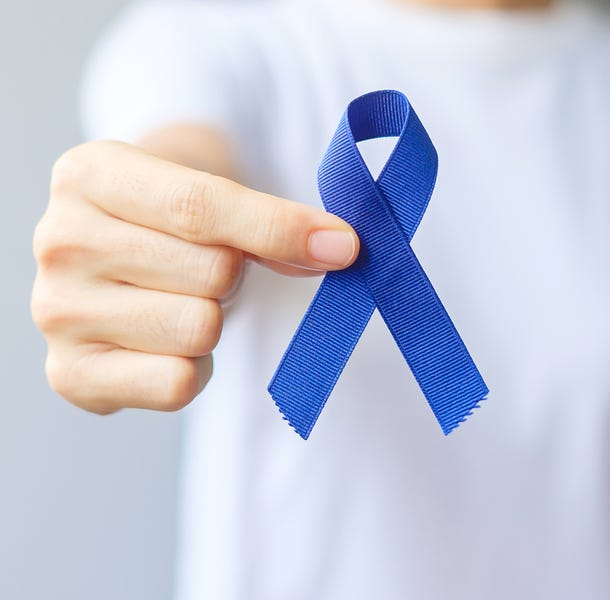 Een persoon met een blauw lint, dat symbool staat voor de strijd tegen darmkanker.