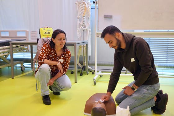 Een man en vrouw kijken naar een dummy