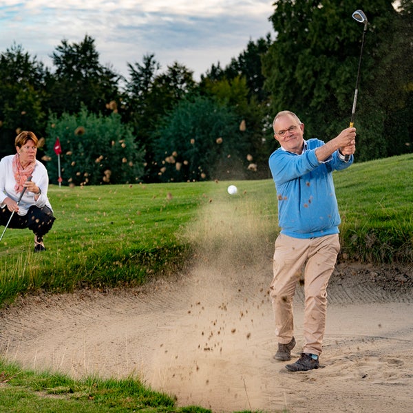 Een man zwaait met een golfclub