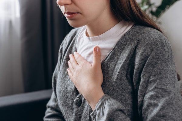 Vrouw met hand op hart door hartklachten