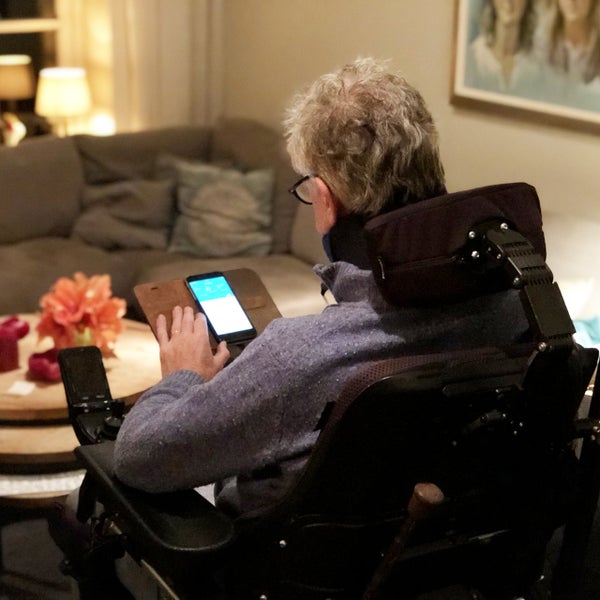 Patiënt in rolstoel gebruikt smartphone