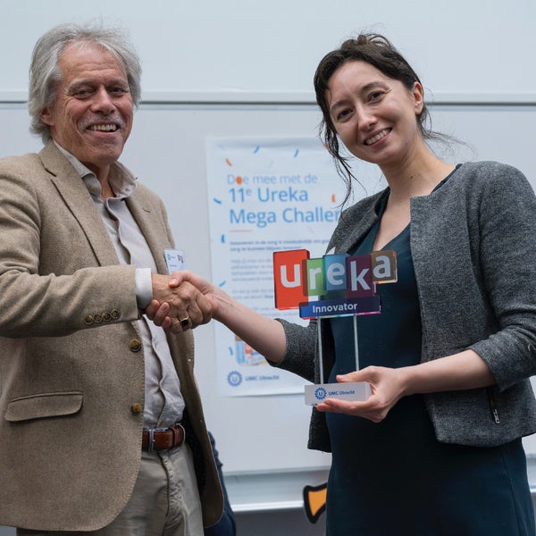 Arno Hoes feliciteerd Julia Berezutskaya van het UMC Utrecht, met ‘Alphabet’ winnaar van de Ureka Mega Challenge 2025.