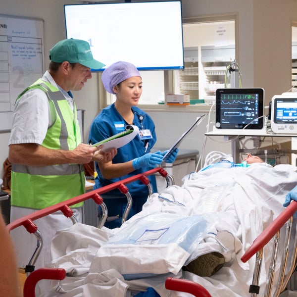 Een slachtofferacteur ligt in een ziekenhuisbed en wordt geholpen door zorgverleners tijdens de jaarlijkse oefening van het Calamiteitenhospitaal.