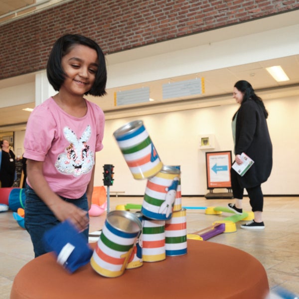 Kinderen spelen met blikken in het WKZ op Nijntje Beweegdag.