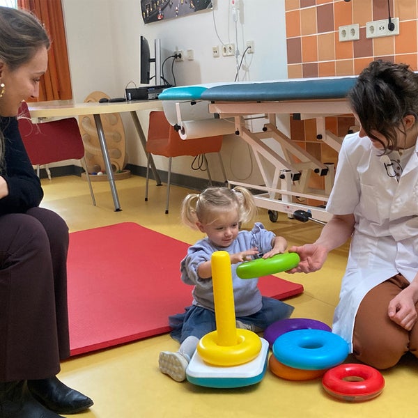 Een vrouw en een kind spelen met speelgoed