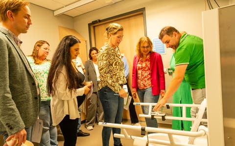 De ouderrraad van het Wilhelmina kinderziekenhuis krijgen uitleg over rolstoel toegankelijk toilet 