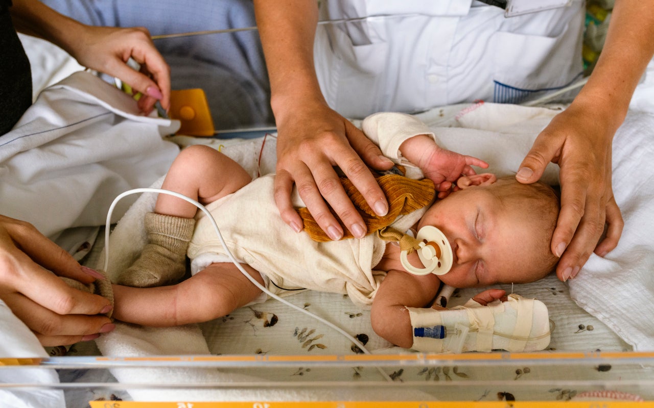 Pasgeboren baby in een ziekenhuisbedje.