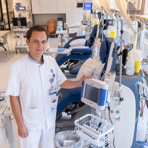 Mark Jordaans op de dialyseafdeling naast een dialyseapparaat.