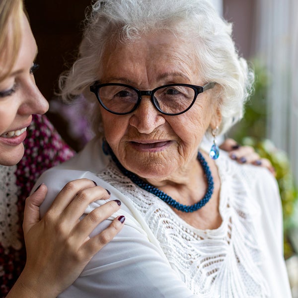 Een vrouw houdt een oude vrouw vast