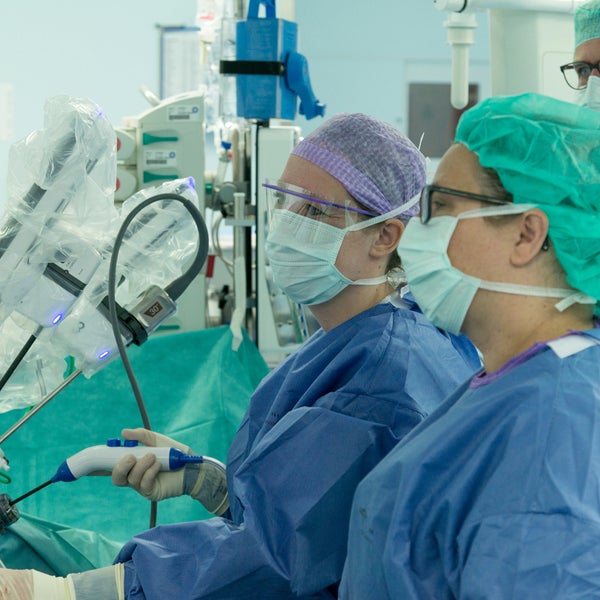 Twee chirurgen besturen een operatierobot.