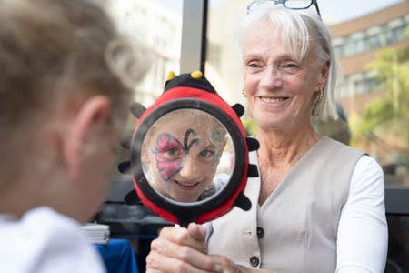 Tijdens de opening van de nieuwe binnentuin van het WKZ werd er ook geschminkt. Een kindje kijkt in de spiegel naar de vlinder die op haar gezicht is geschminkt.