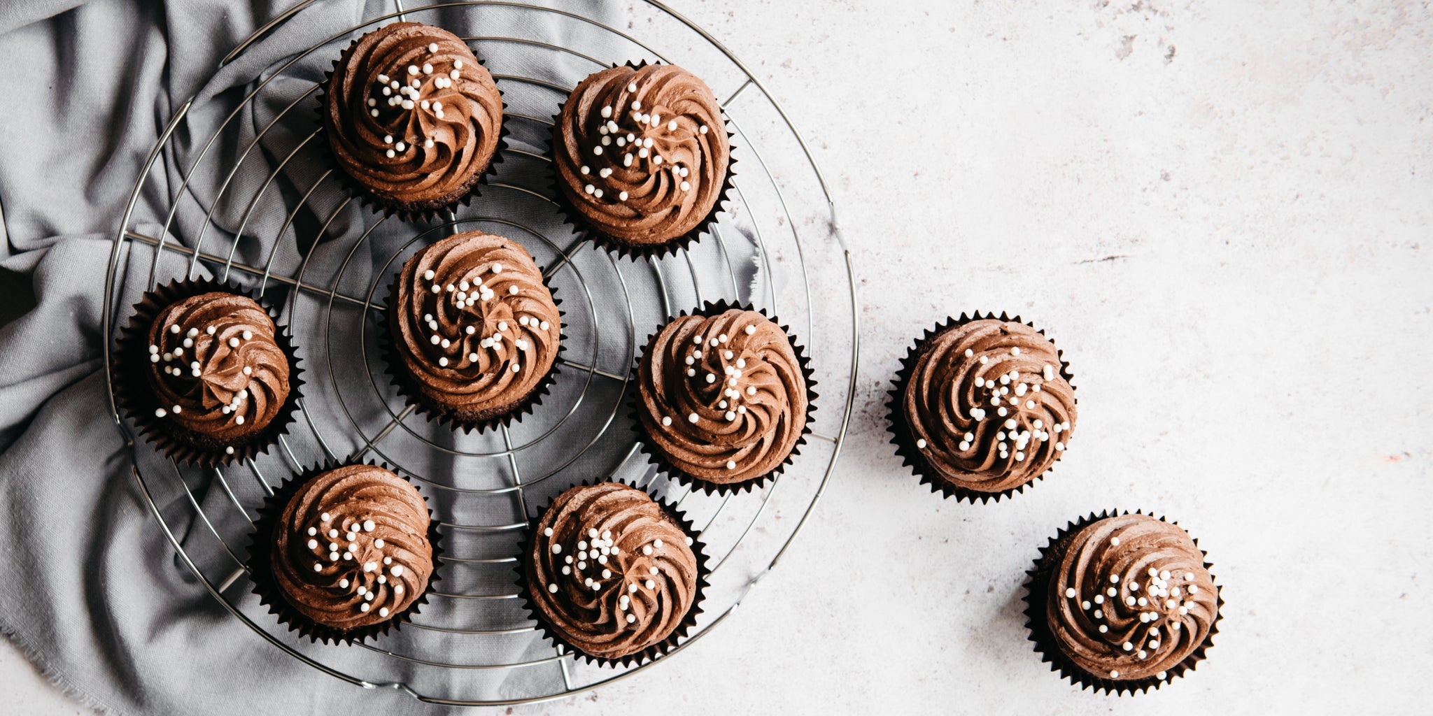 Top view of Wholemeal Chocolate Cupcakes on a wire rack, decorated with chocolate buttercream