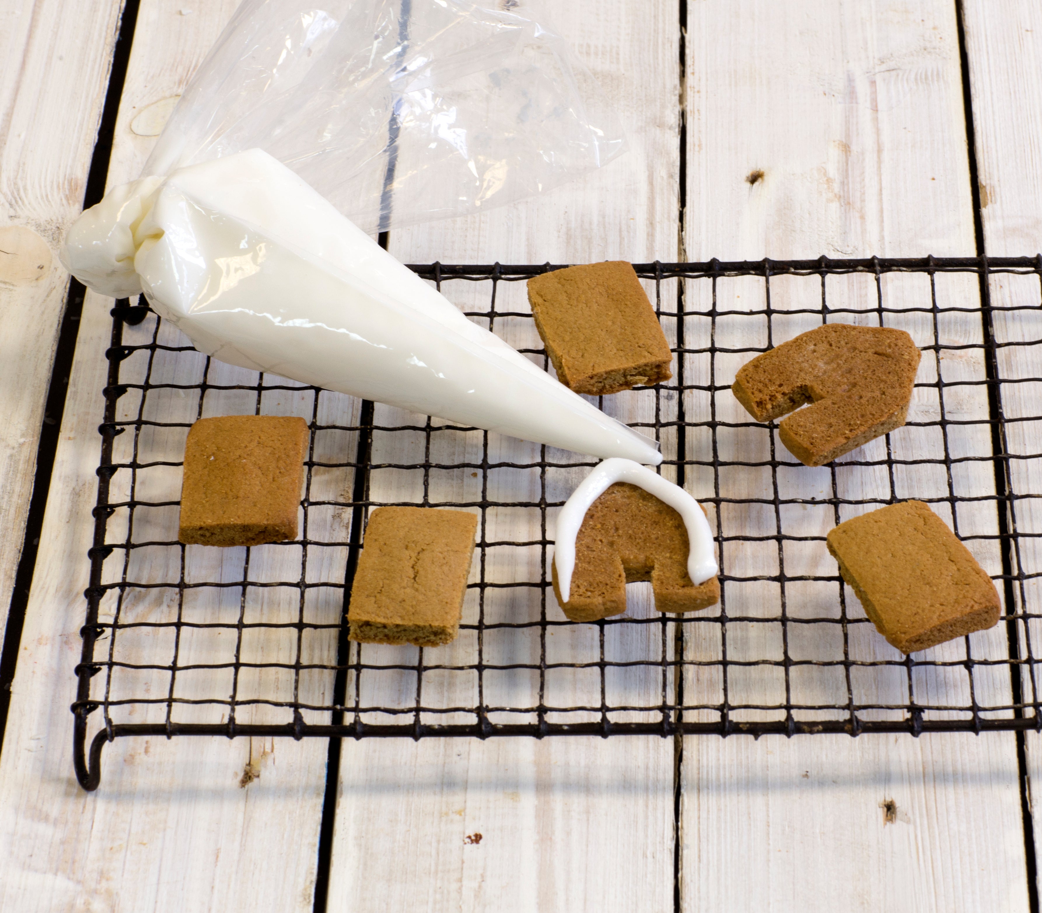 Baked gingerbread house shapes with icing bag 