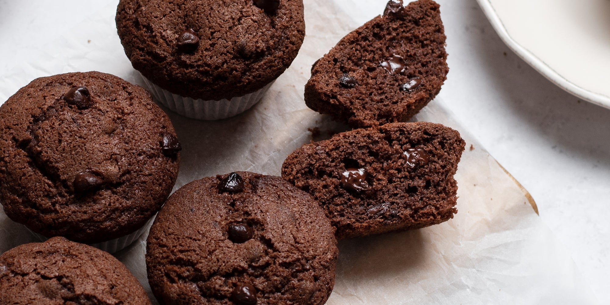 Close up of Gluten Free Chocolate Muffins cut in half showing melted chocolate chips in the middle