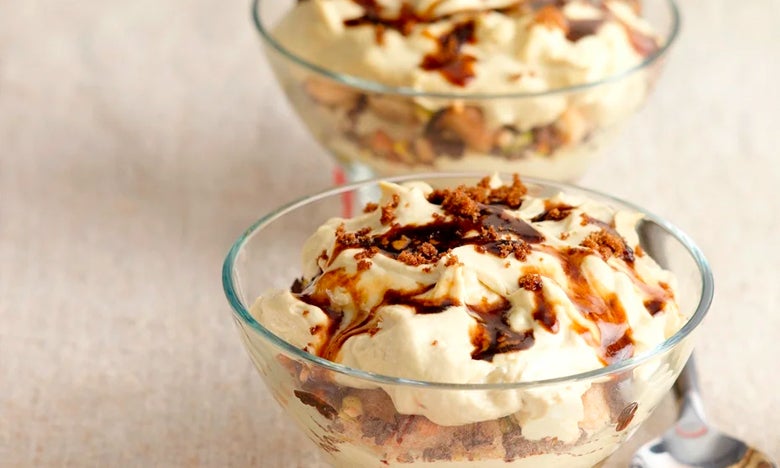 Two glass bowls of tiramisu sprinkled with dark muscovado sugar