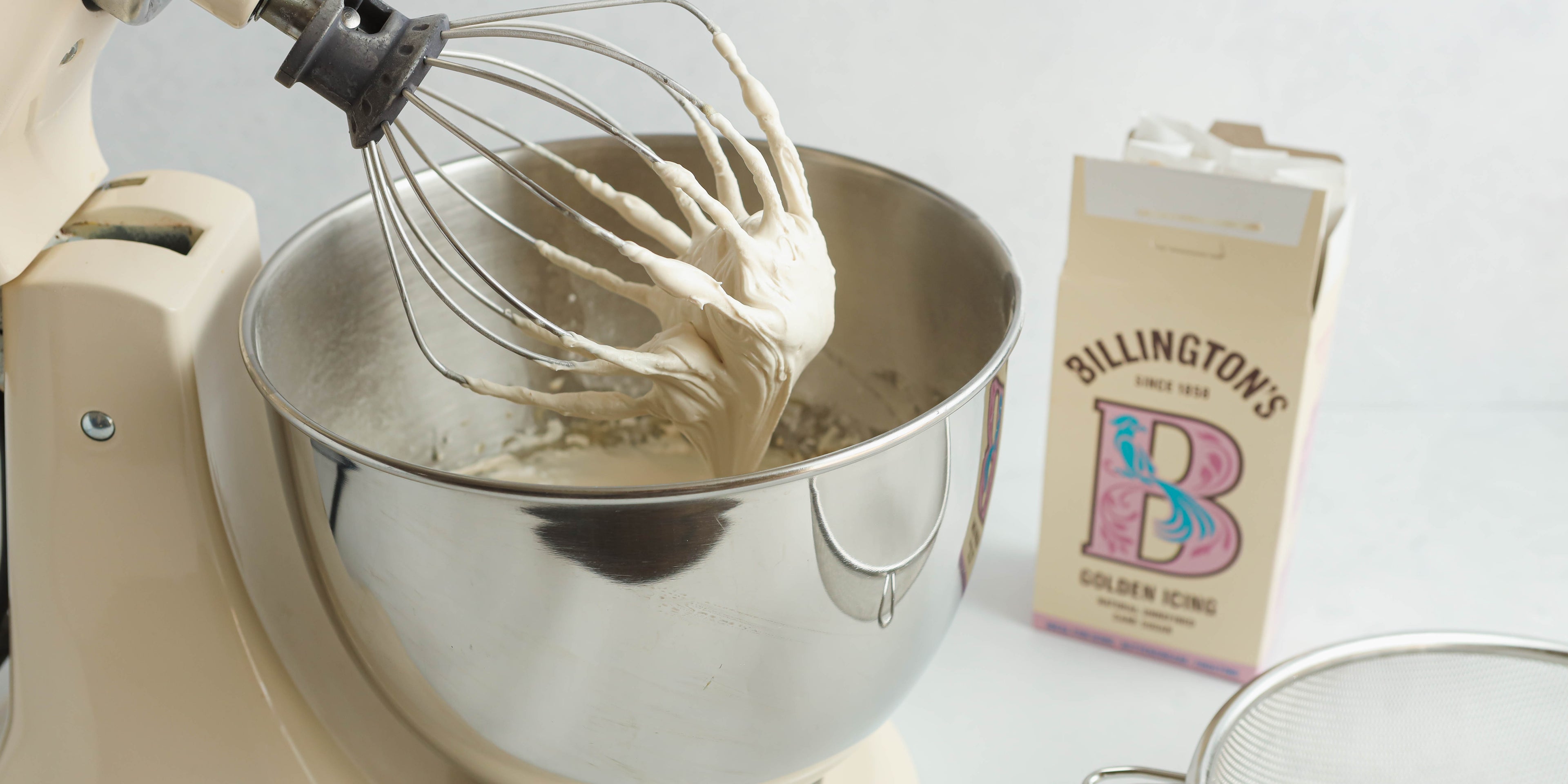 Close up of a whisk creating buttercream using Billington's Golden Icing Sugar