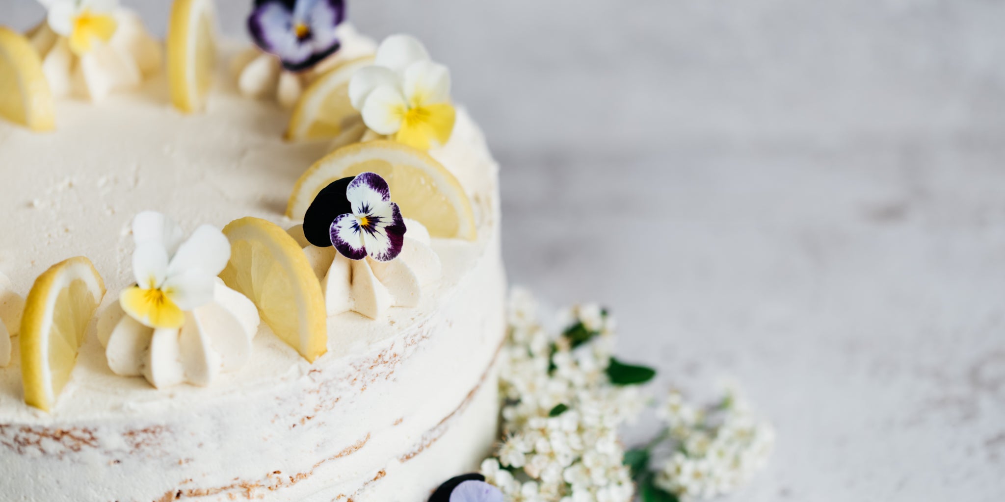 Close up of cake topped with lemon slices and flowers