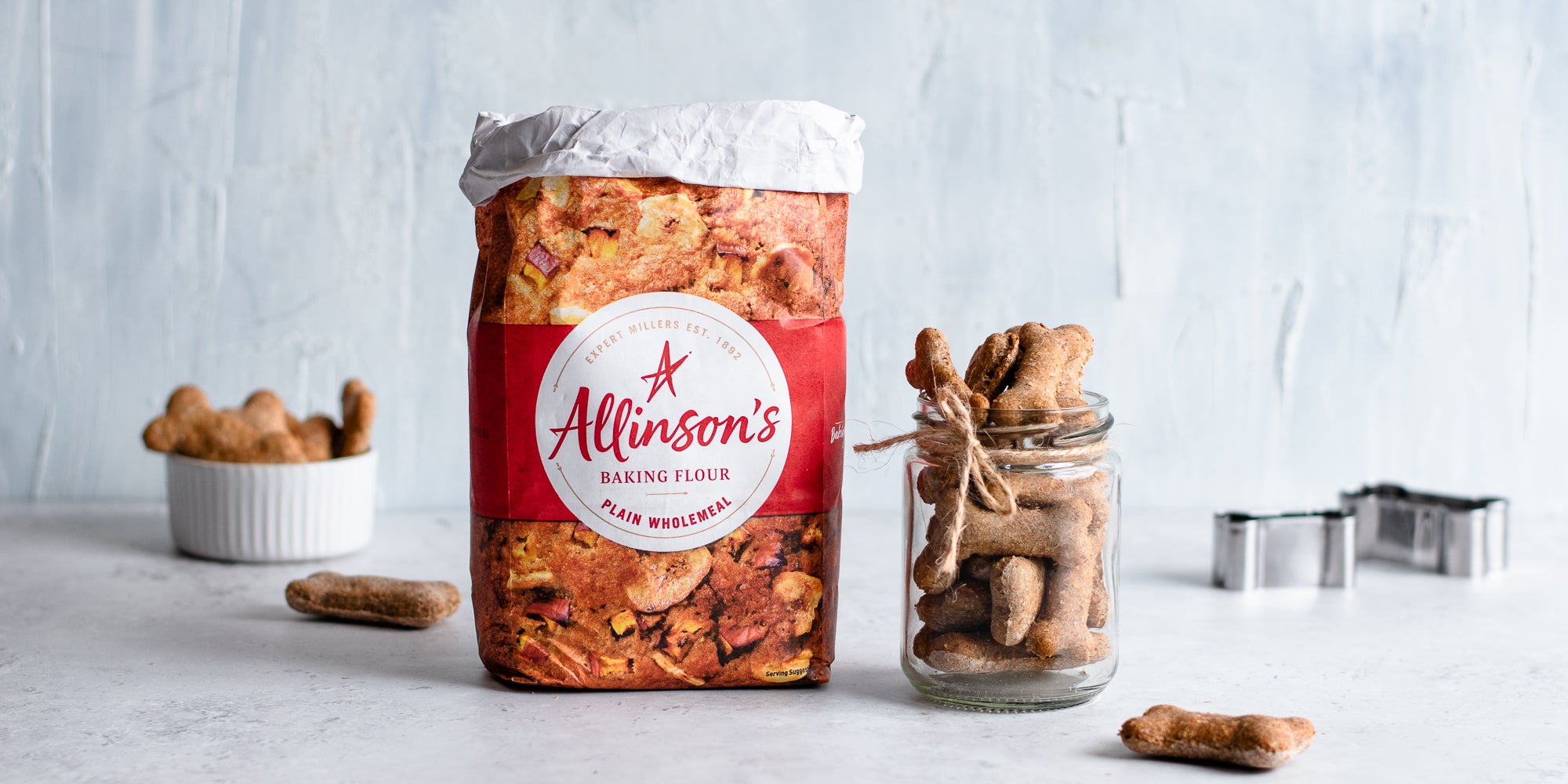 Dog Biscuits in a glass jar next to a bag of Allinson's Plain flour