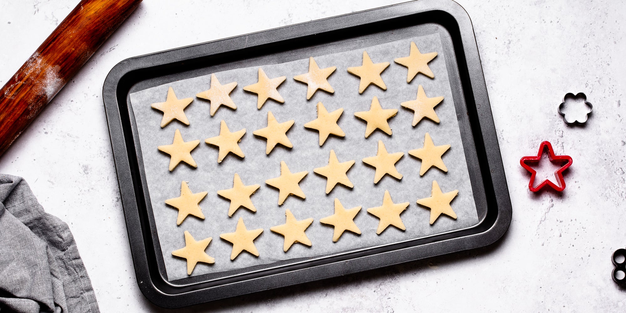 Top down view of vegan biscuit dough stars laid out on a baking tray