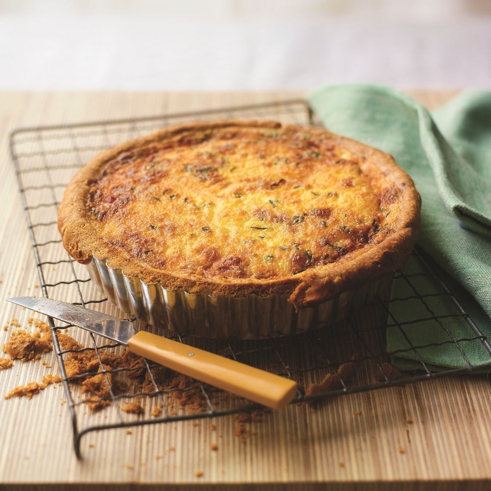 Classic French Quiche Lorraine cooling on a wire rack 