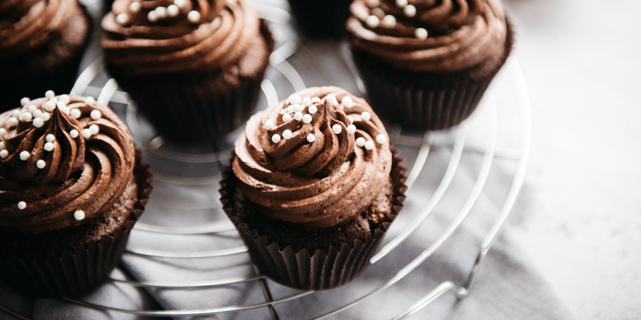 Close up Wholemeal Chocolate Cupcakes on a wire rack, decorated with chocolate buttercream