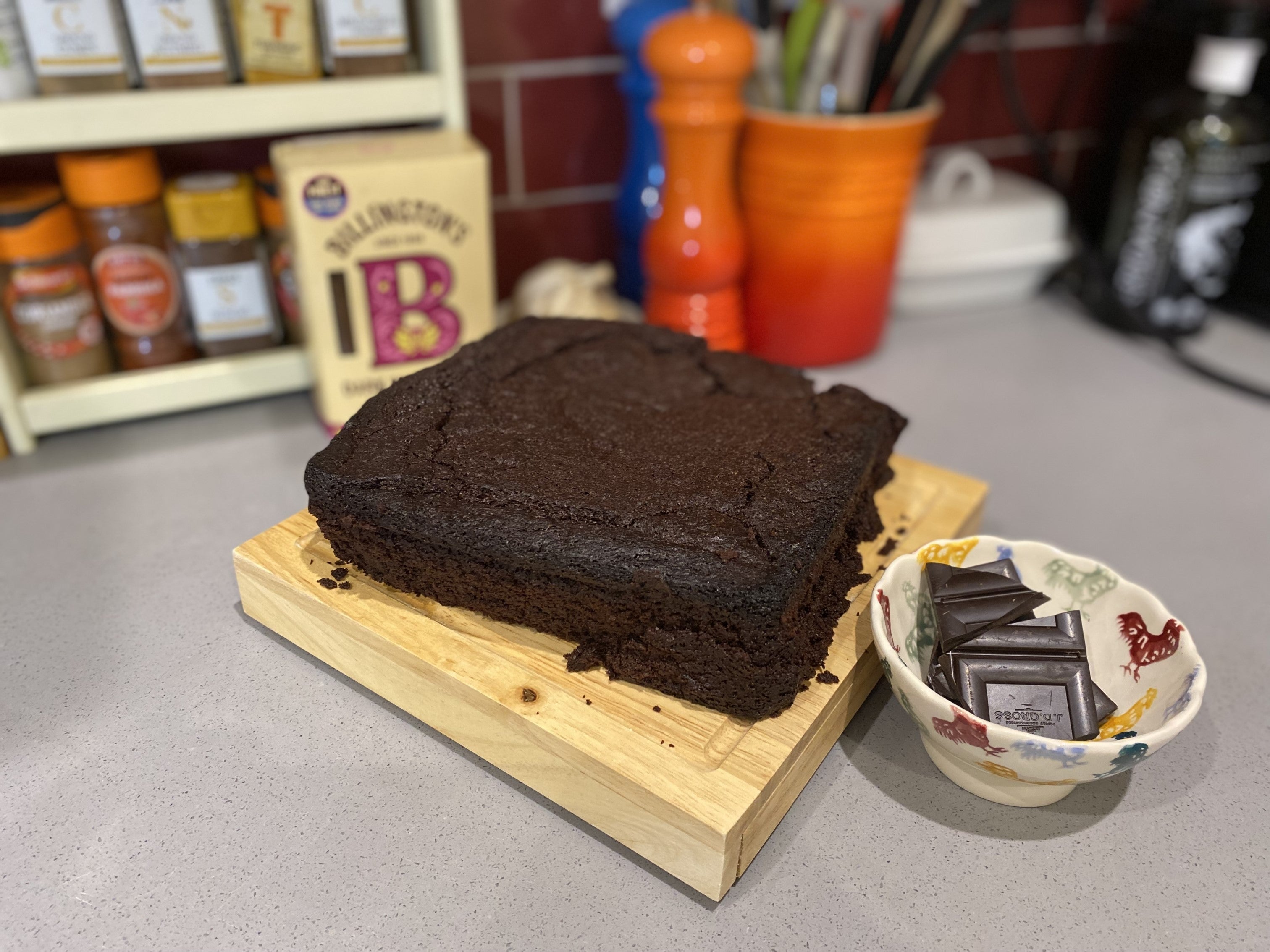A freshly-baked Jamie Oliver brownie on a wooden chopping board