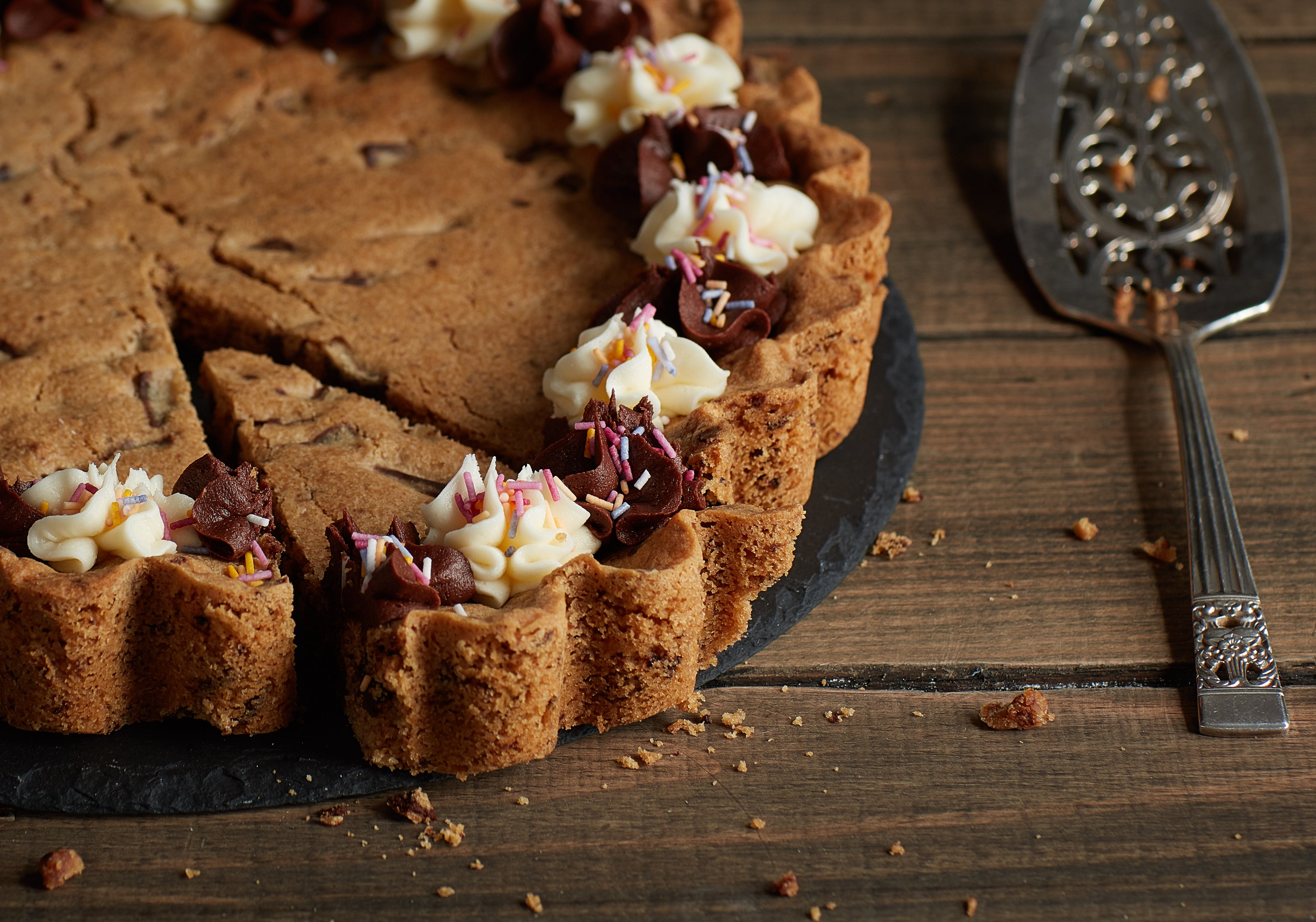 Close up of cookie cake with slice partially removed