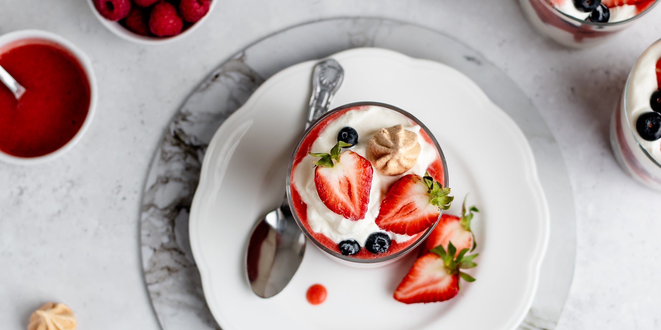 Top view of Summer Berry Eton Mess garnished with fresh sliced strawberry and meringues