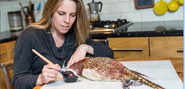 Sarah Hardy decorating a cake in the shape of a pheasant