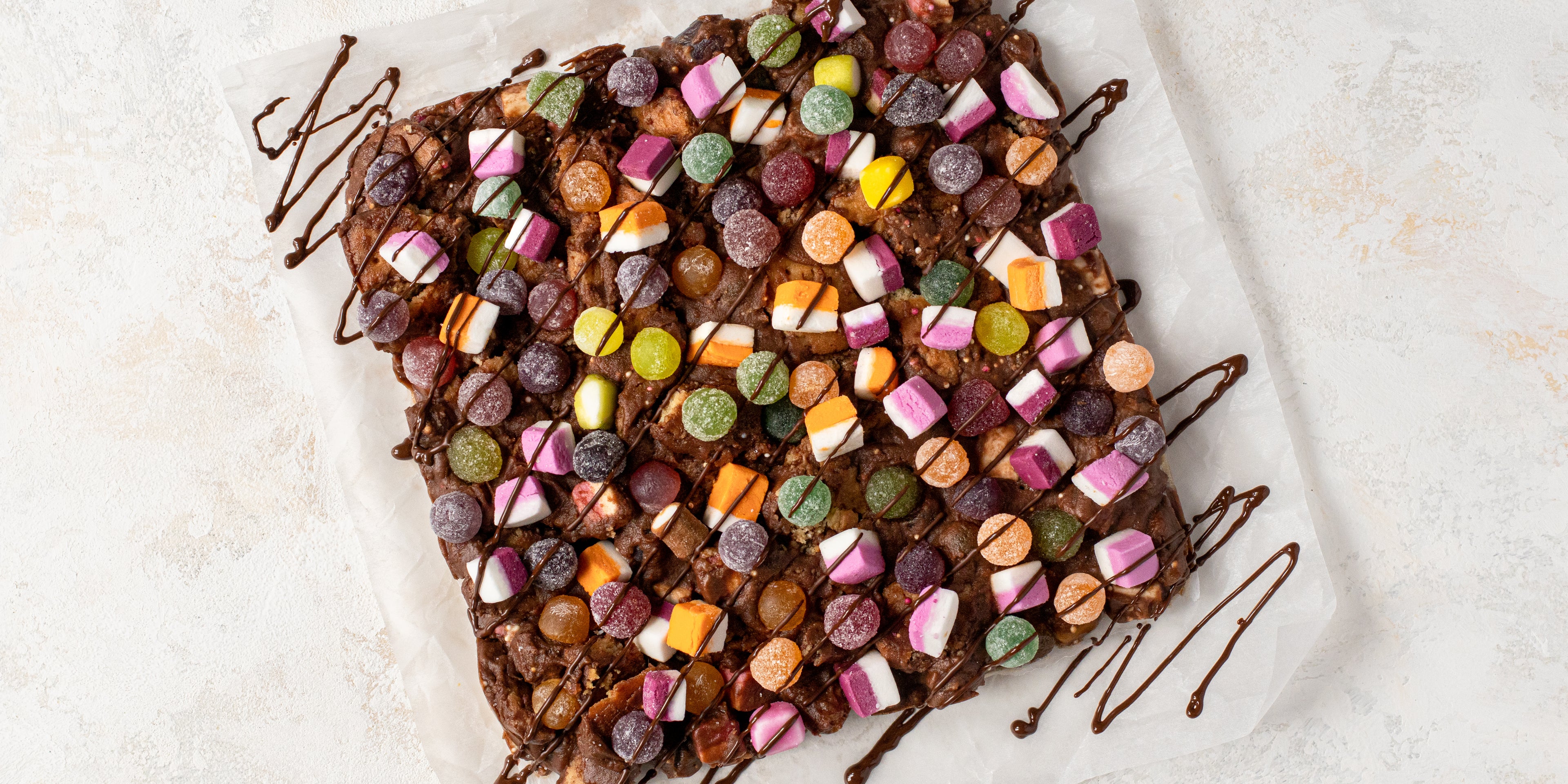 Top view of Sweetie Rocky Road on a sheet of baking paper, drizzled with chocolate