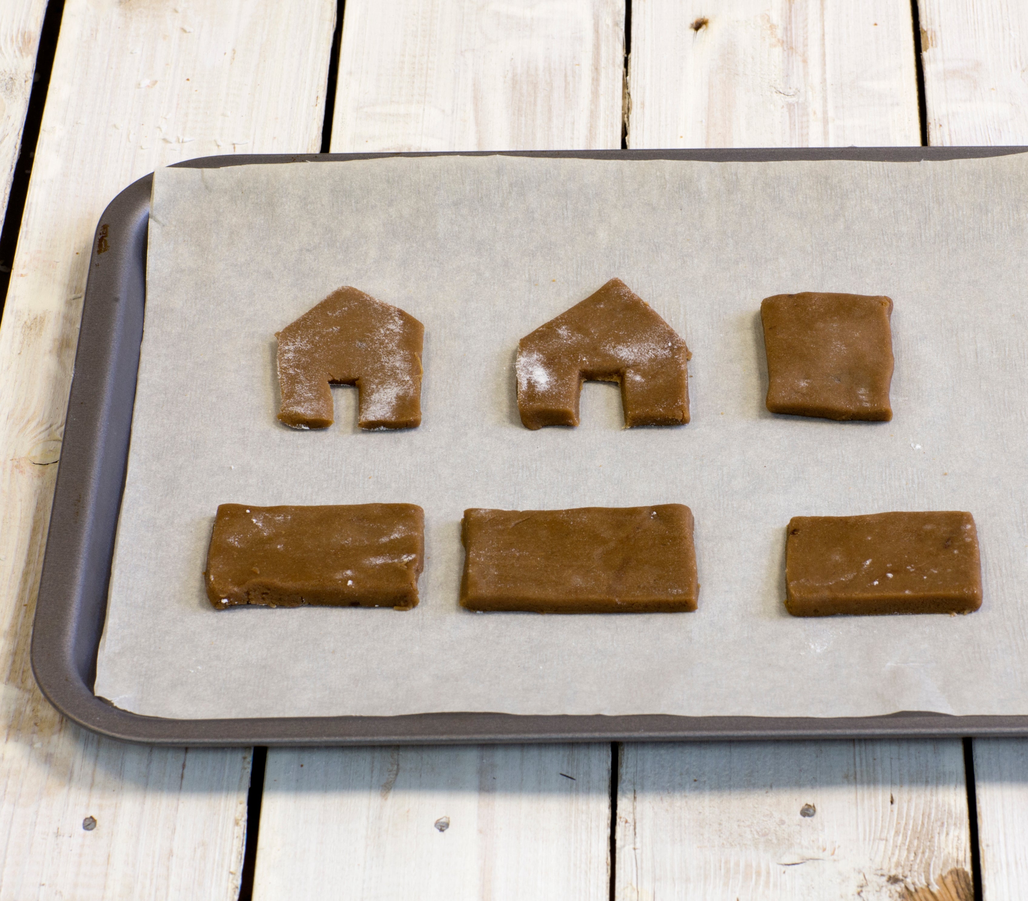 Gingerbread dough shapes laid out on baking tray