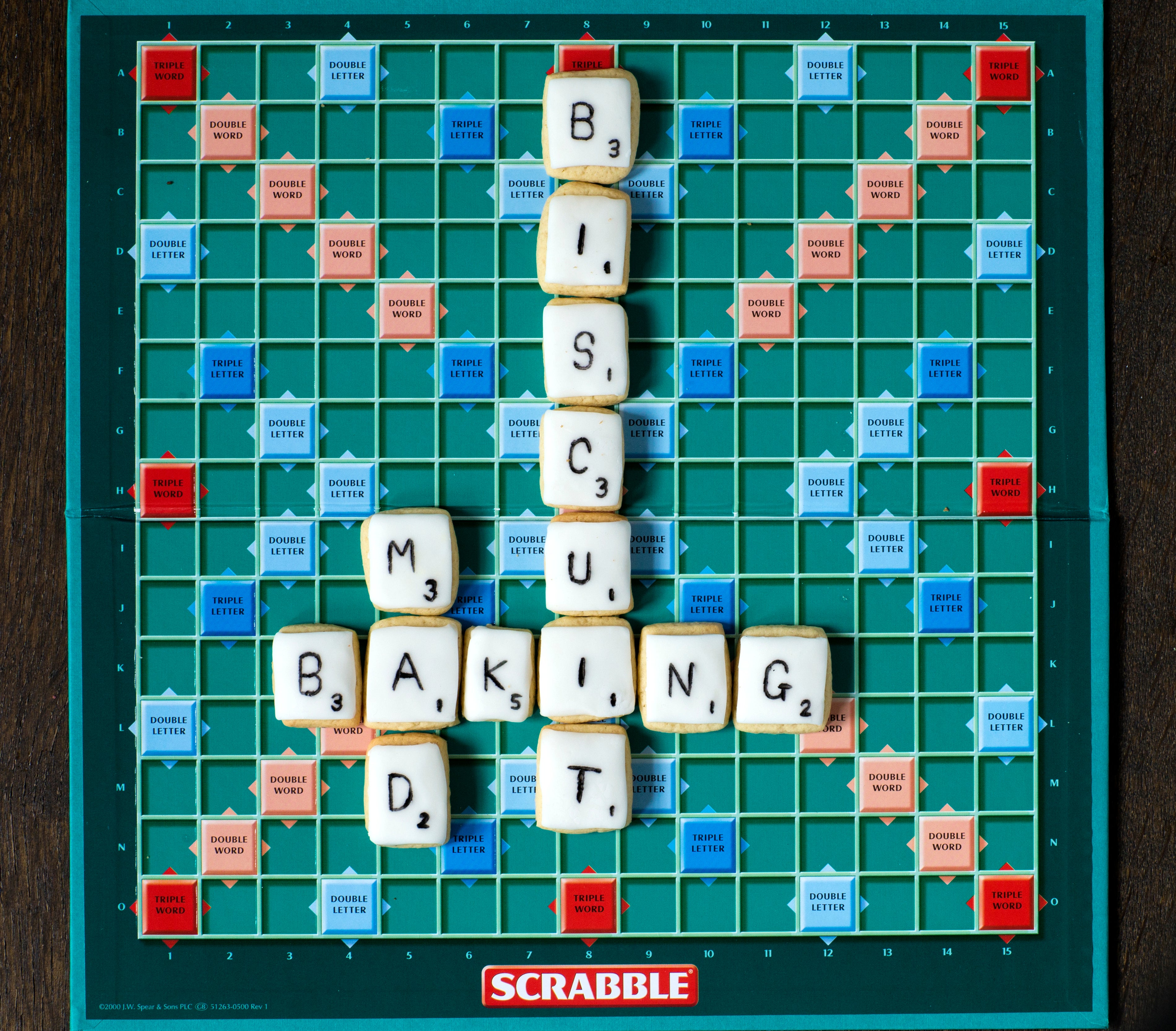Overhead shot of a scrabble board with iced biscuits on