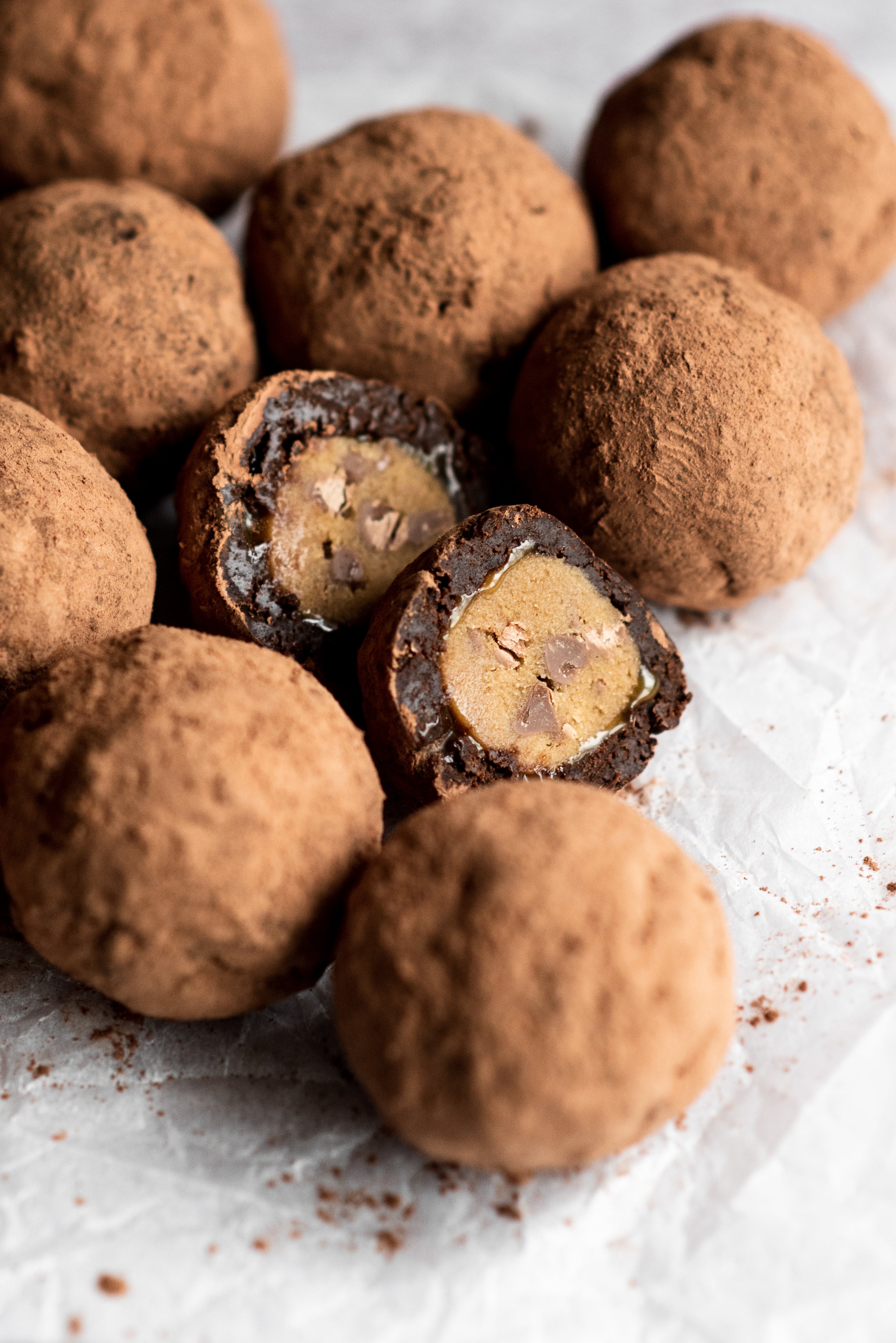 Close up of cocoa dusted brownie truffles with one split in half