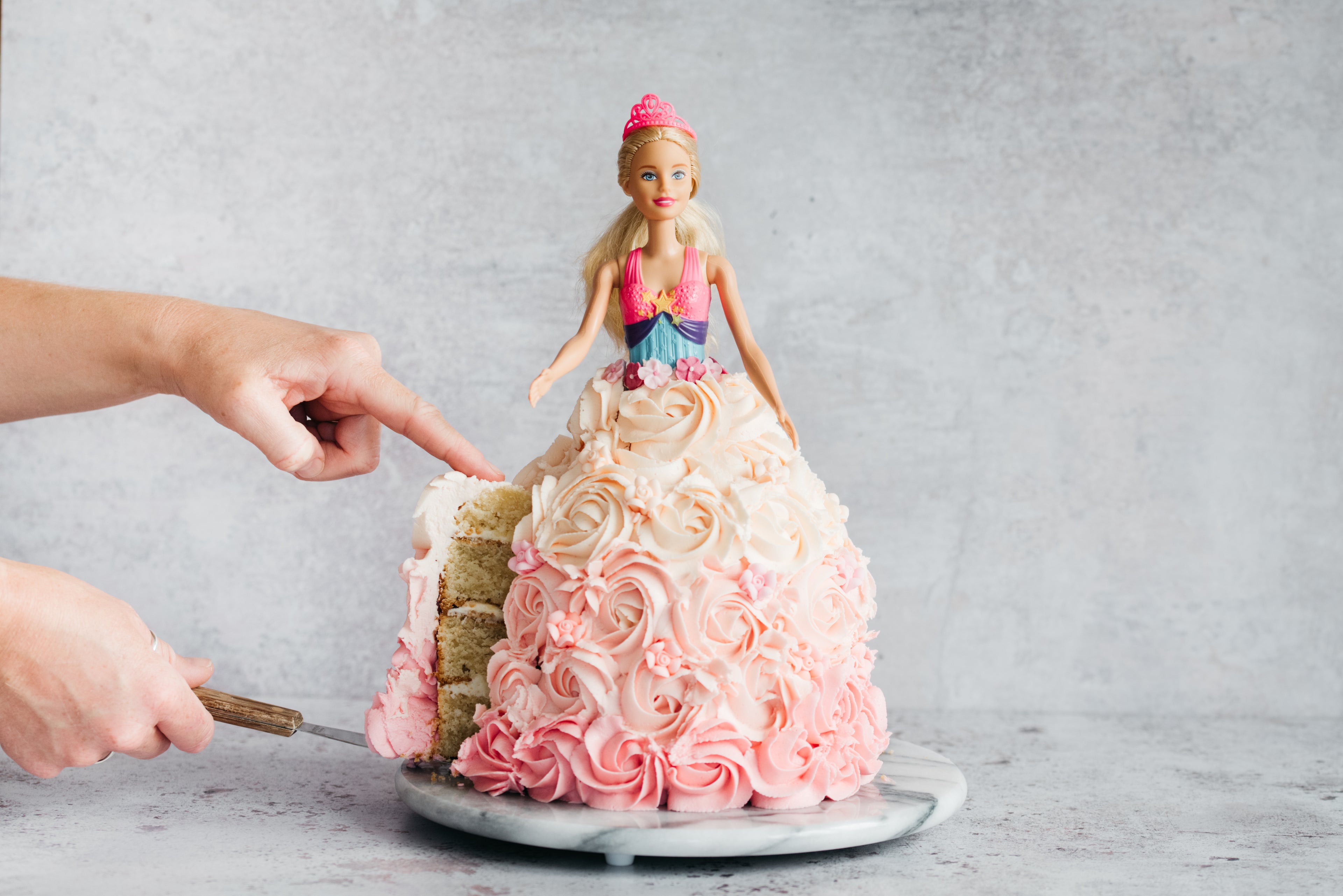 Close up of Princess Barbie Cake dress being cut into showing the four layers inside