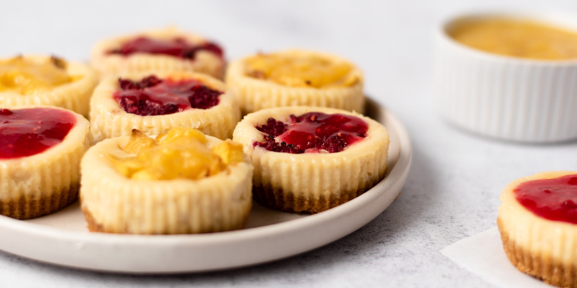 Plate of mini cheesecakes topped with fruit