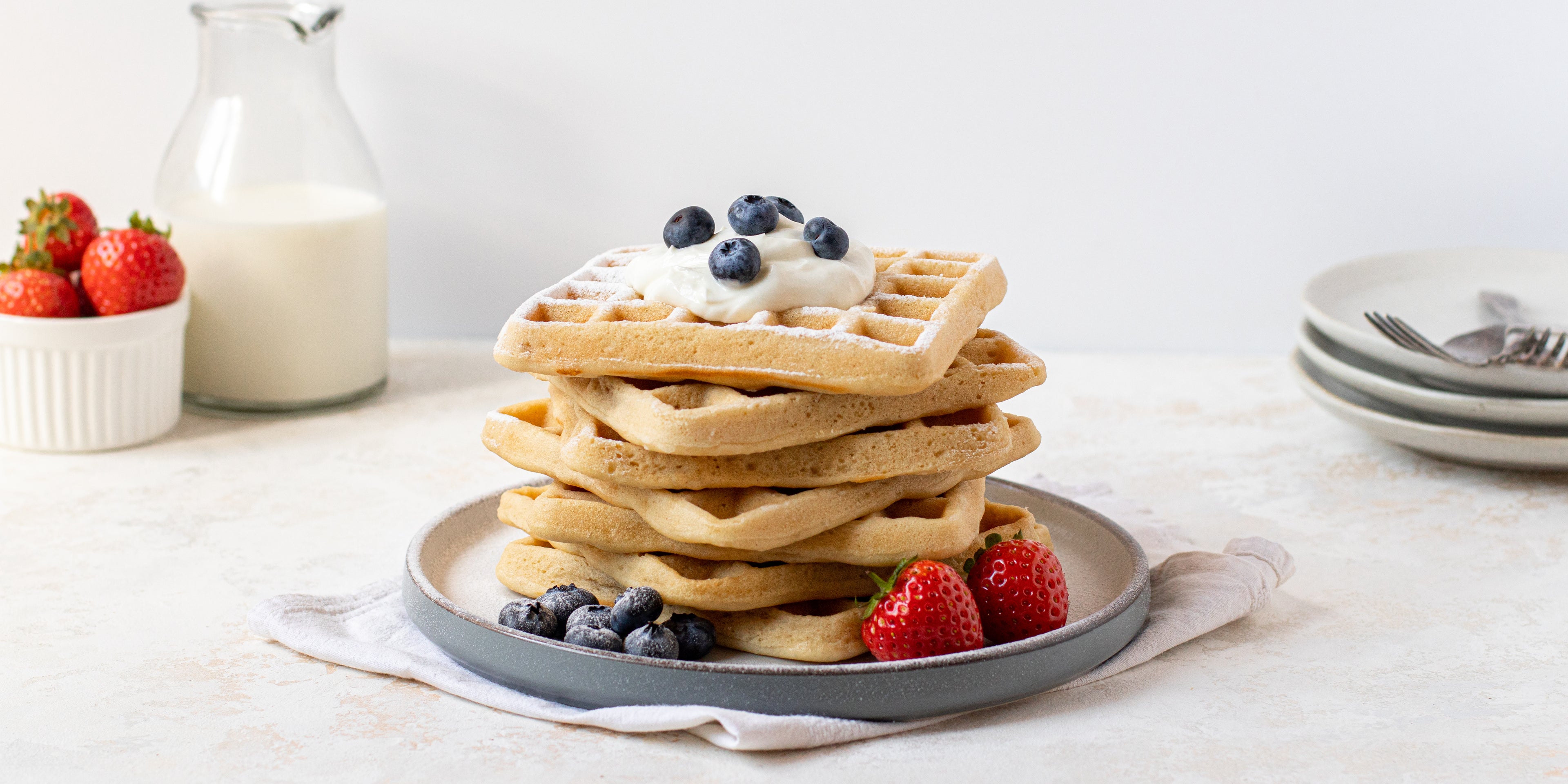 Side on view of a stack of vegan gluten free waffles topped with berries