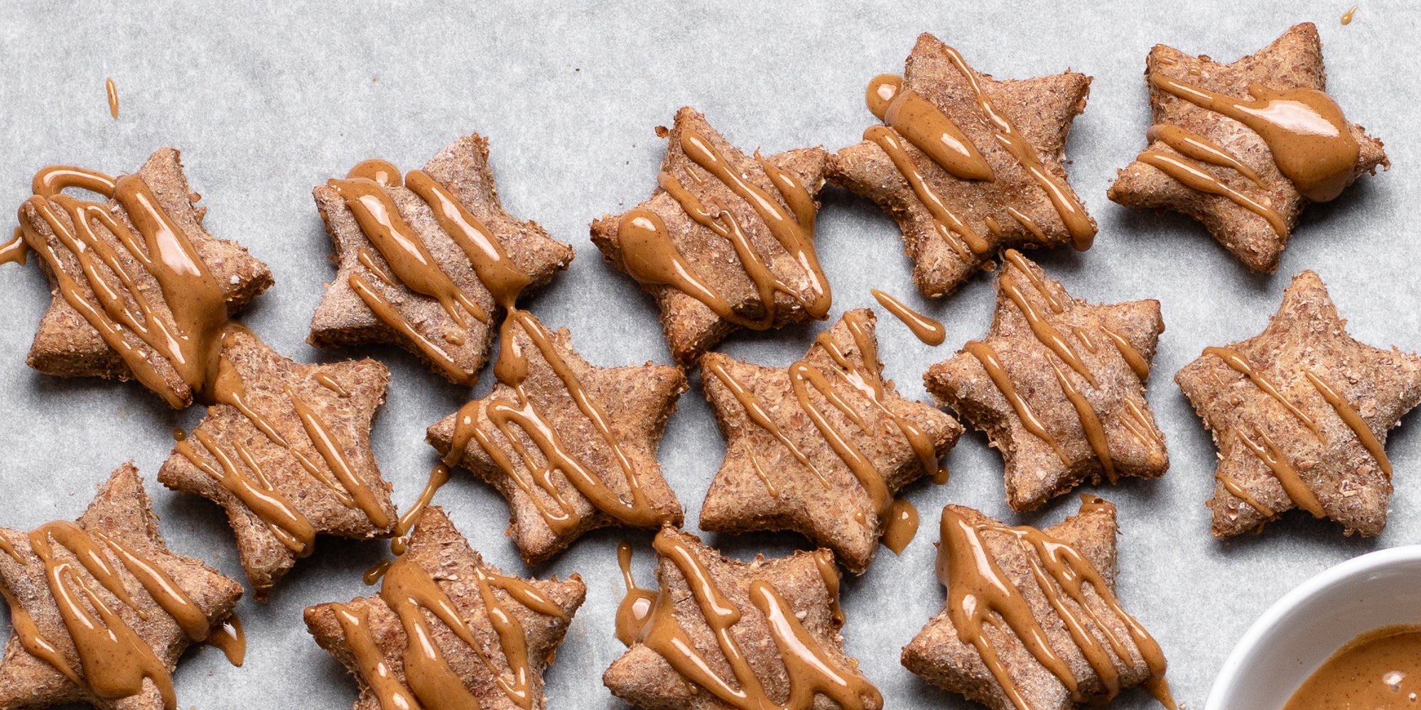 Close up of Dog Biscuits drizzled with Proper Nutty peanut butter