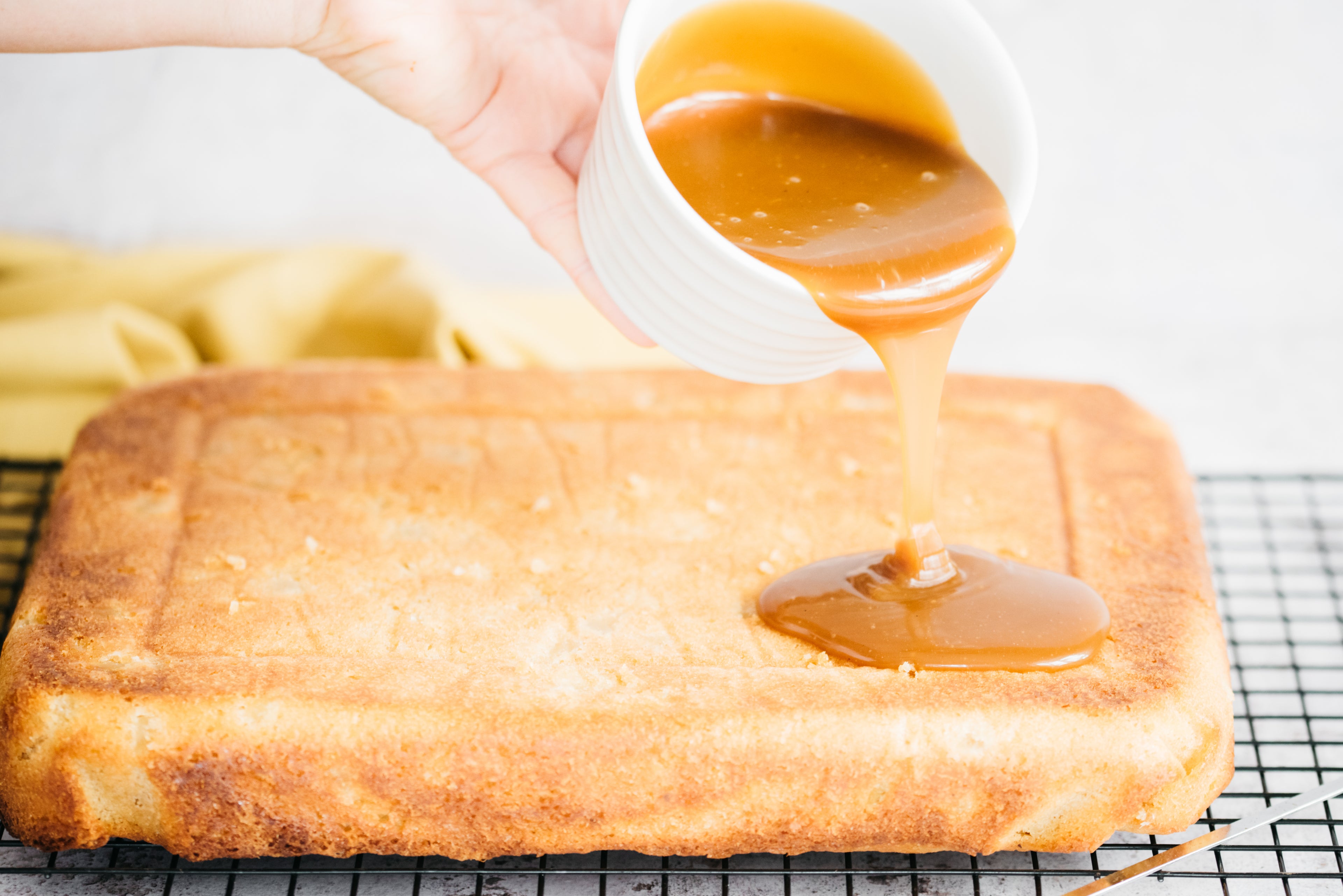 Pouring caramel sauce on top of cake