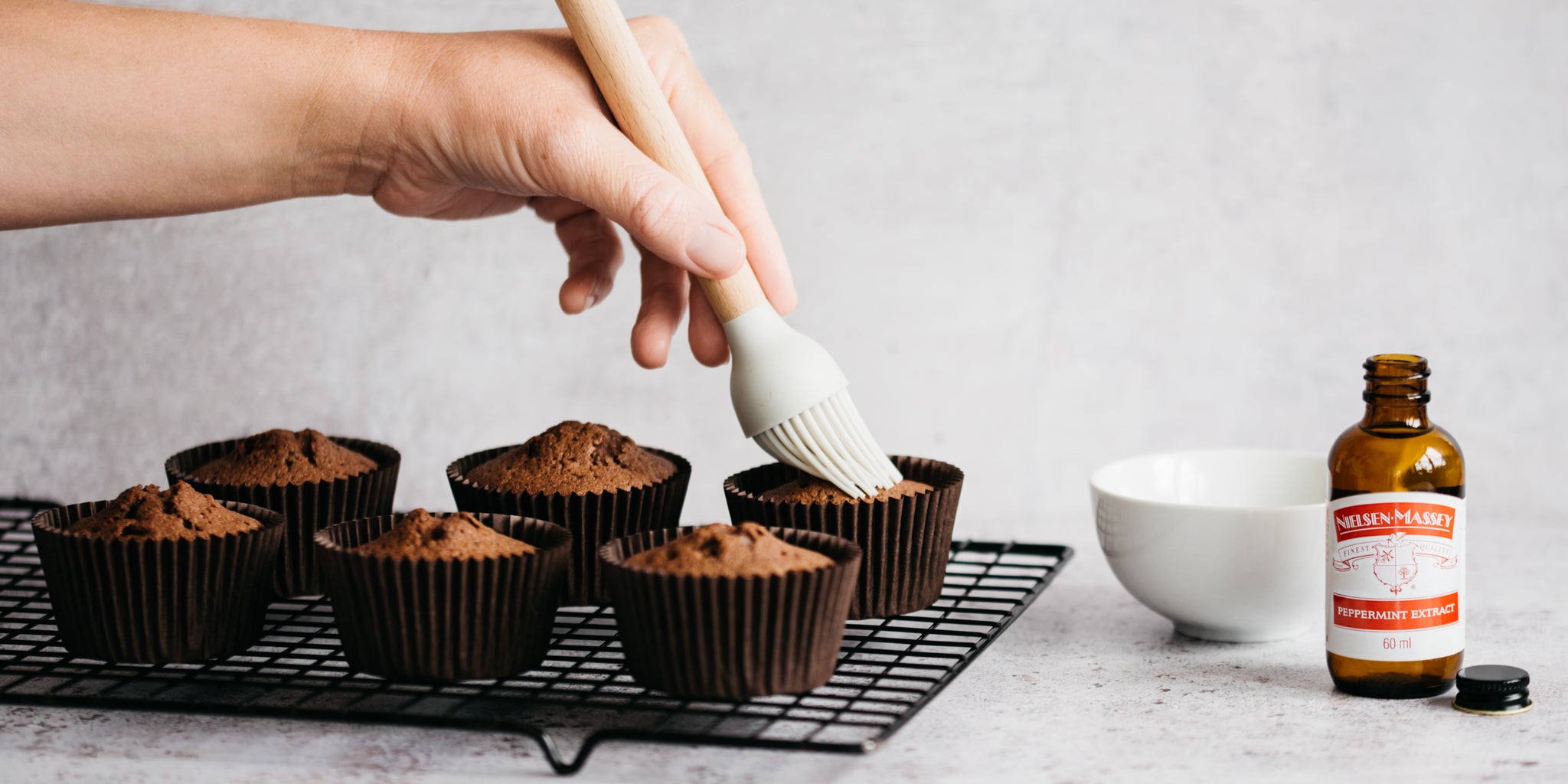 Chocolate & Peppermint Cupcakes being hand brushed with Nielsen Massey Peppermint Extract to infuse the sponge