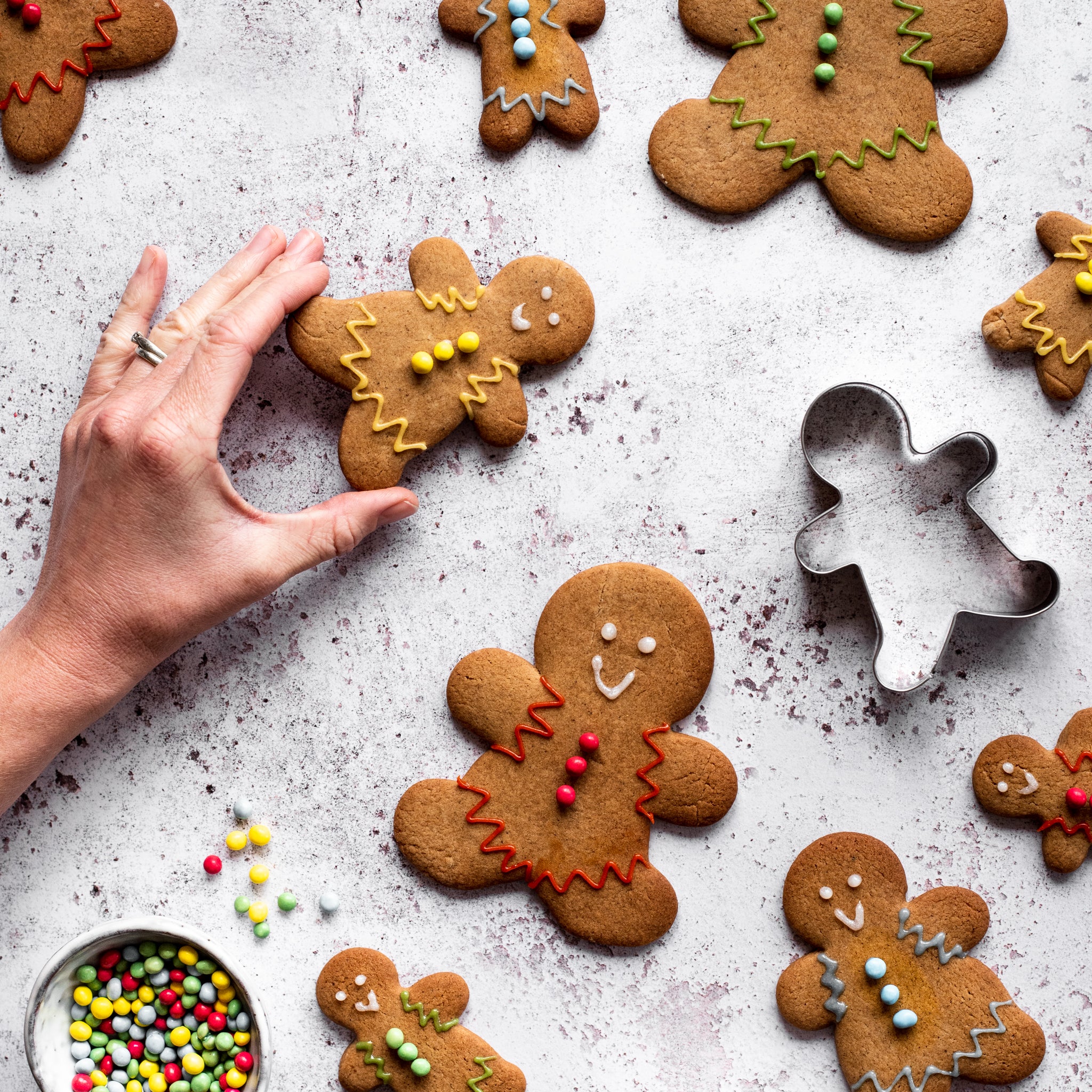 Arranging gingerbread men with multicoloured icing decoration