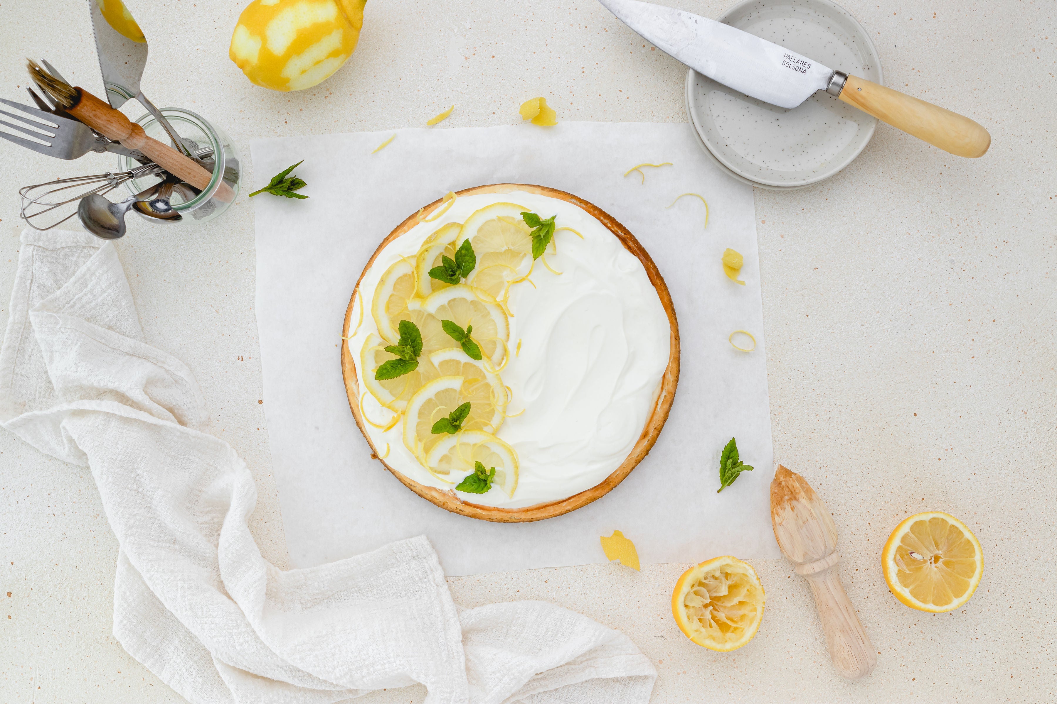 Overhead shot of lemon cheesecake with squeeze lemon and knife