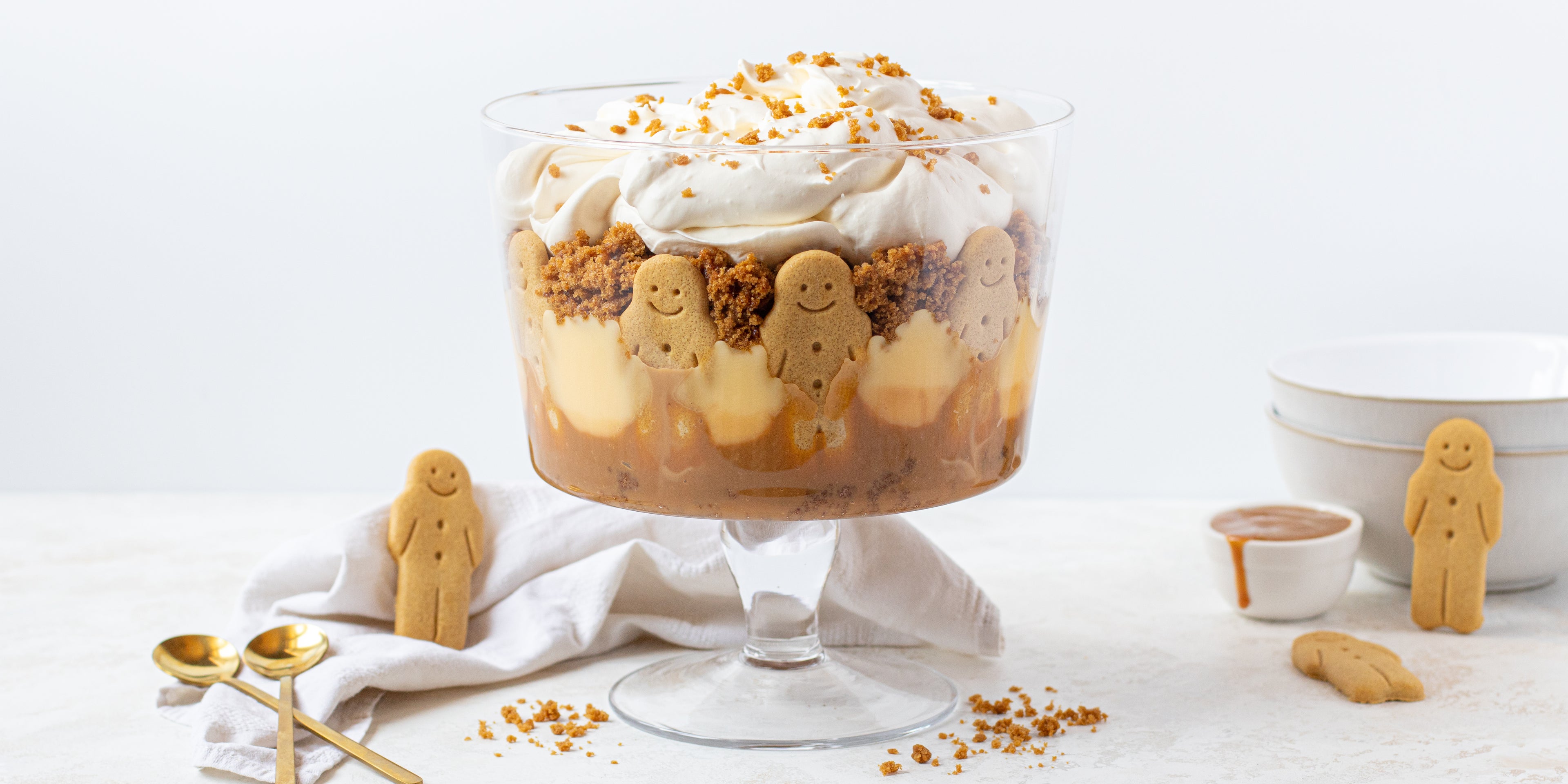 Gingerbread Trifle layered with gingerbread men, custard and cream, with gingerbread men surrounding the trifle bowl