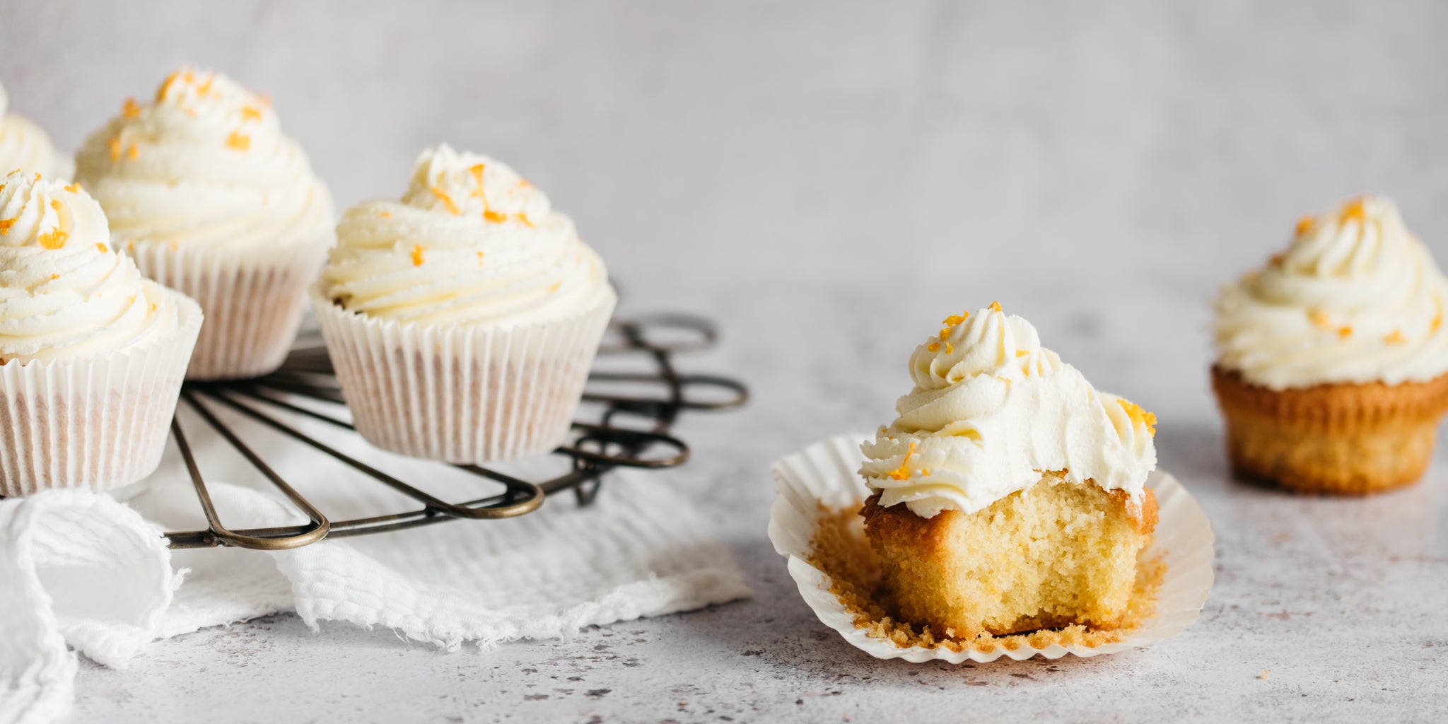 Orange Blossom Cupcakes with a bite taken out of a cupcake showing the fluffy insides