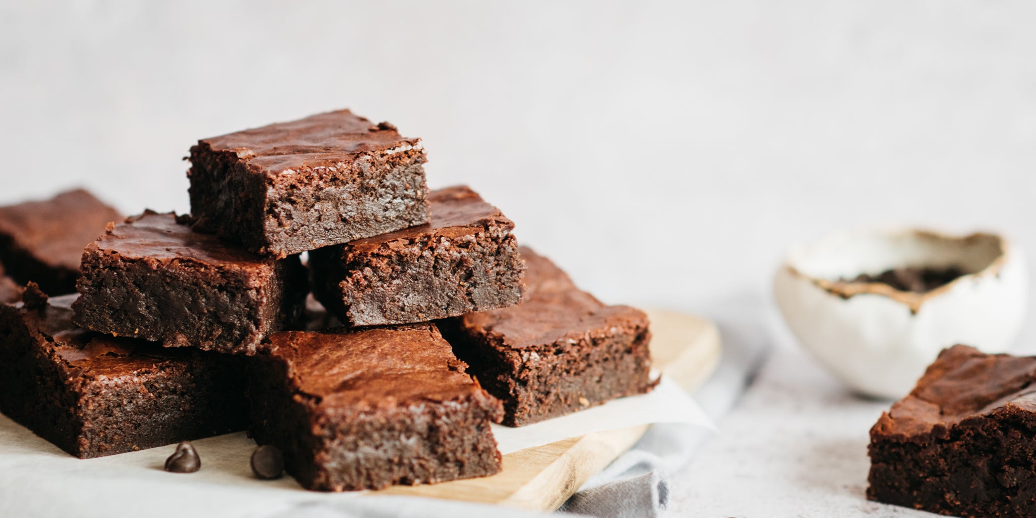 Wholemeal Chocolate Brownie close up, served on parchment paper on a chopping board